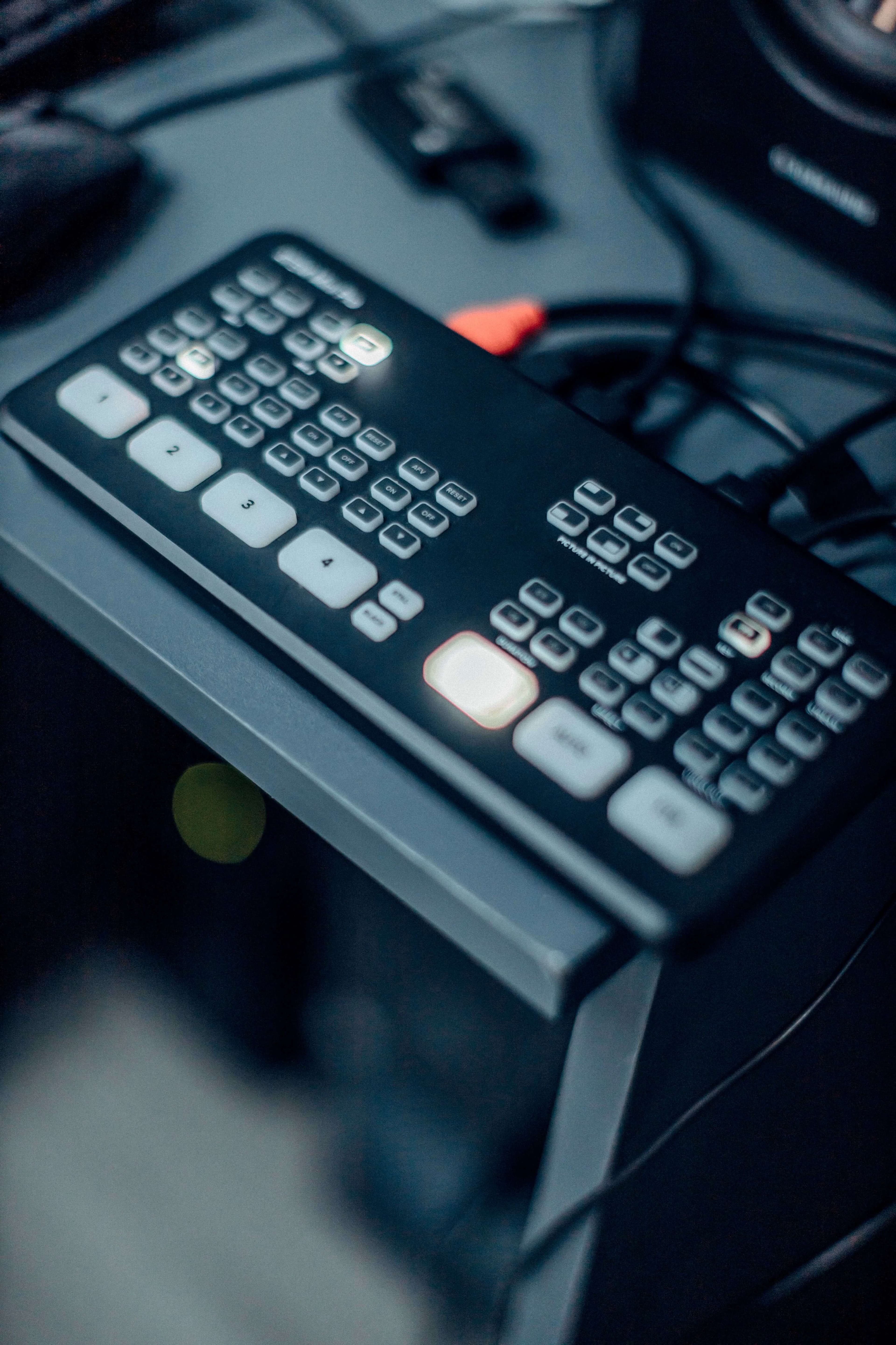 A close-up of a video switcher's control panel, with numbered camera source buttons lit during a live broadcast.